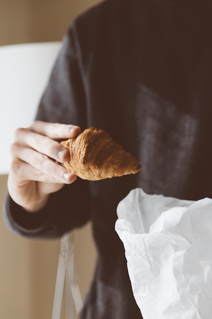 Hand holding croissant