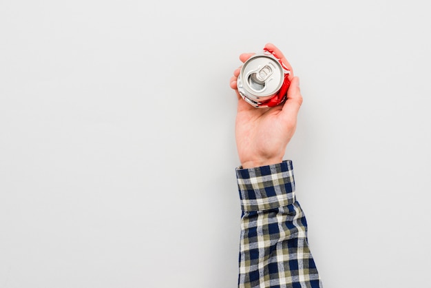 Free photo hand holding crumpled can of drink