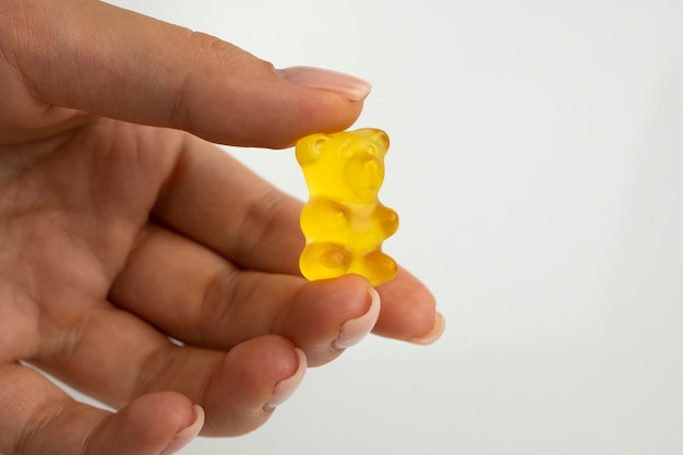 Free photo hand holding delicious gummy bear candy