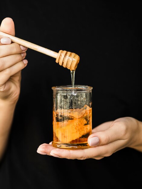 Hand holding delicious honey jar