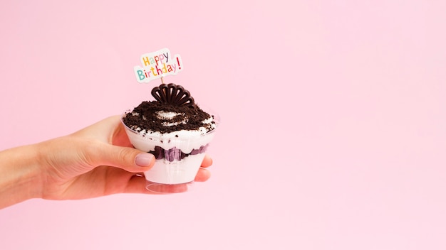 Hand holding dessert with happy birthday sign