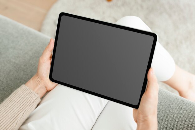 Рука держит цифровой планшет с пустым черным экраном
