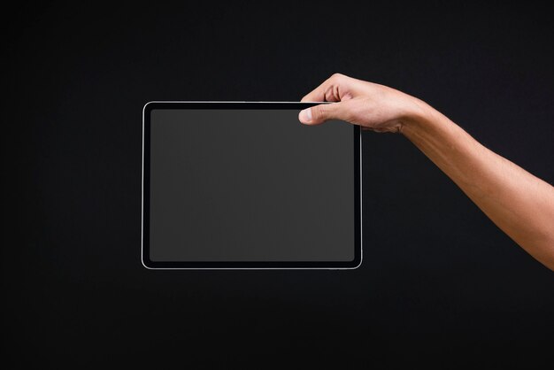 Hand holding digital tablet with blank black screen