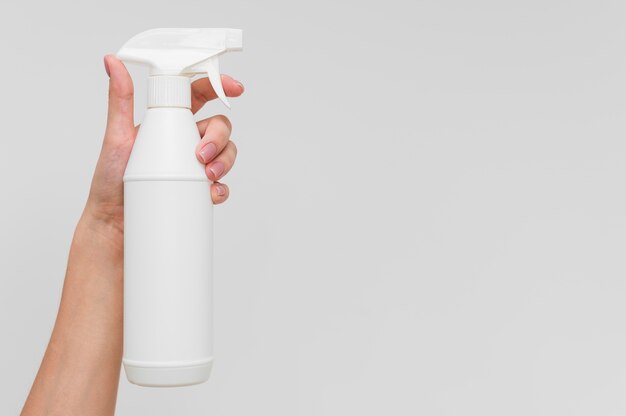 Hand holding disinfectant in bottle with copy space