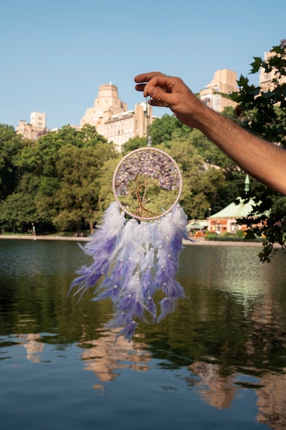 Free photo hand holding dream catcher outdoors