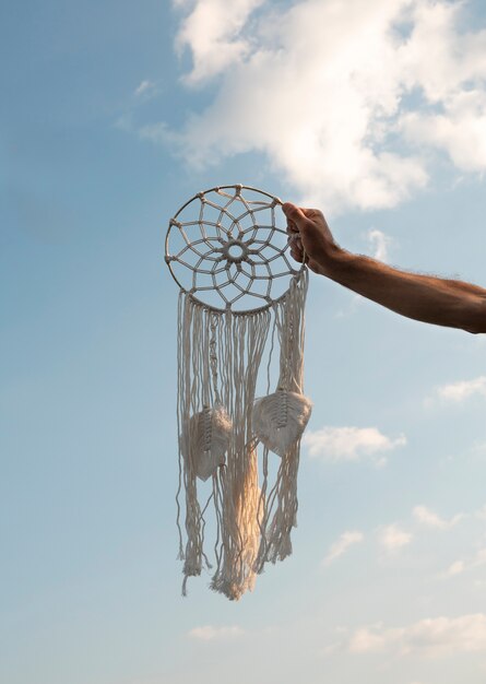 Hand holding dream catcher outdoors