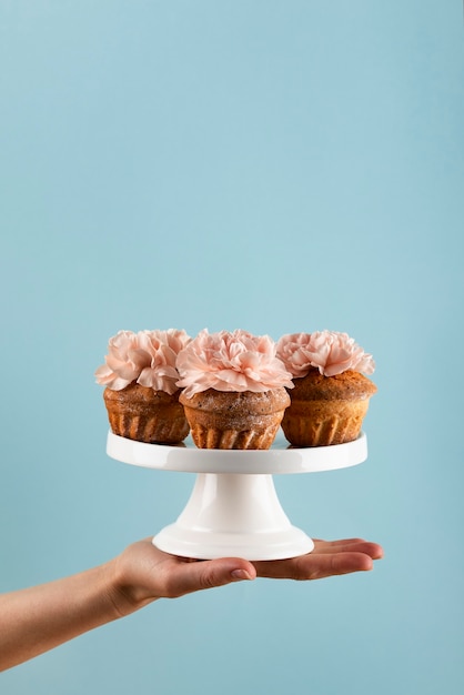 Foto gratuita cupcakes ecologici con fiori in mano