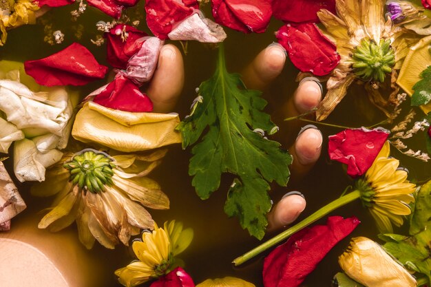 Hand holding flowers in black water