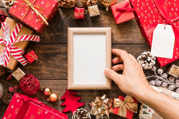 Hand holding frame between present boxes 