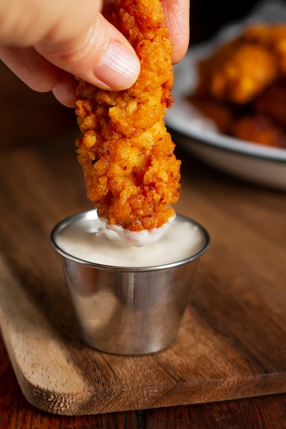 Hand holding fried chicken close up