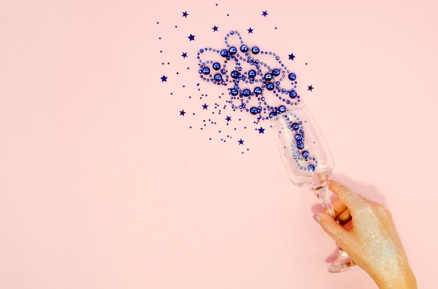 Hand holding glass with confetti