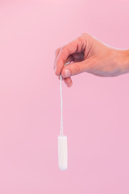 Free photo hand holding hanging tampon