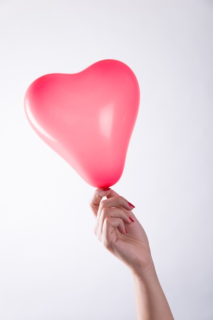 Hand holding heart balloon