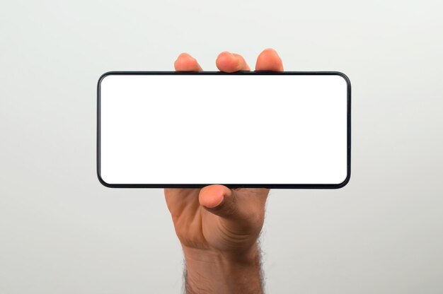 Hand holding a horizontal plain white smartphone