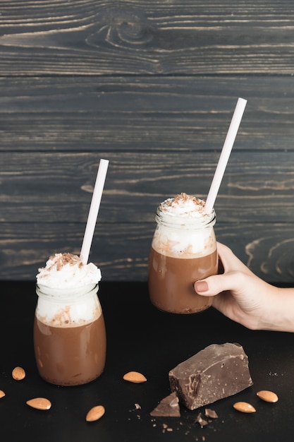 Hand holding hot chocolate with cream