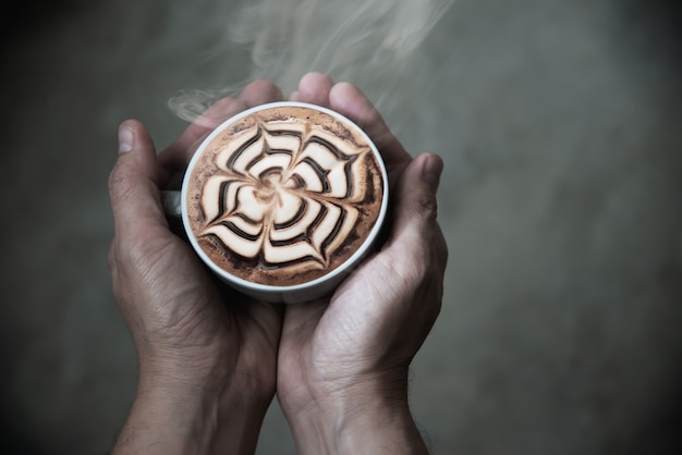 Hand holding hot coffee cup 