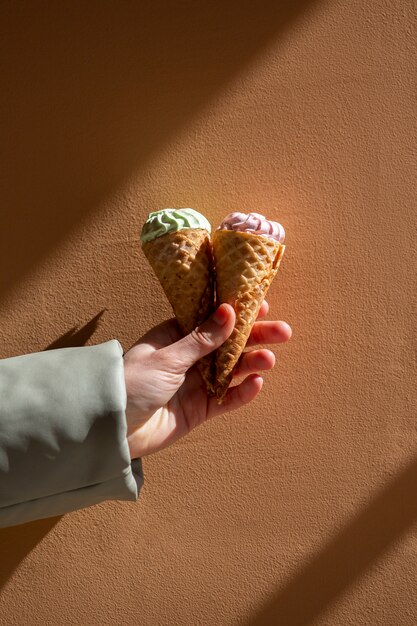 Hand holding ice cream cones outside