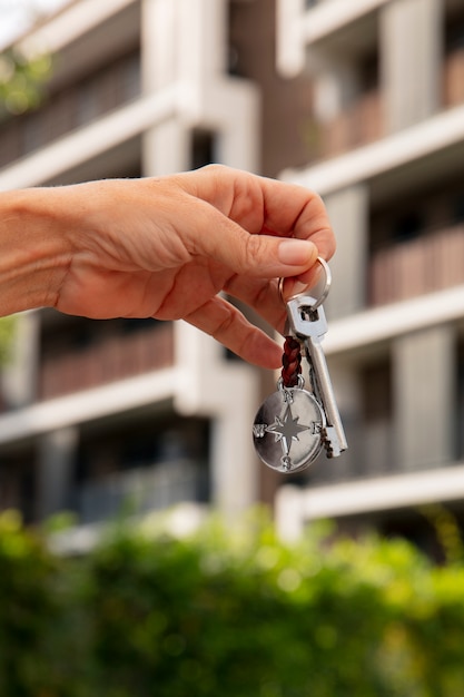 Free photo hand holding key outdoors