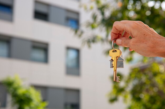 Hand holding key outdoors