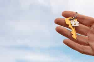 Free photo hand holding key with copy space