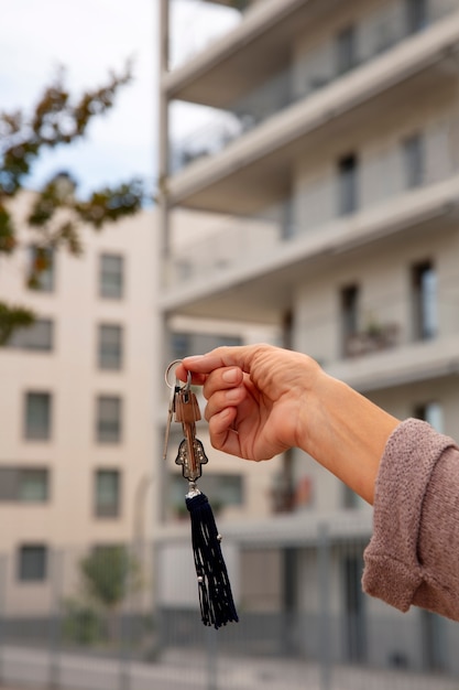 Free photo hand holding keys outdoors