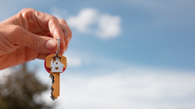 Free photo hand holding keys outdoors