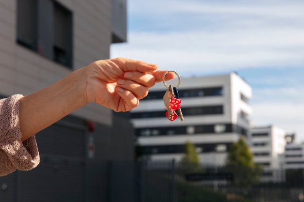 Free photo hand holding keys outdoors