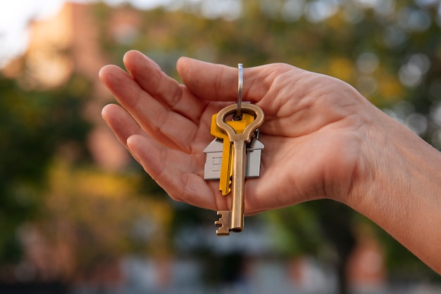 Free photo hand holding keys outdoors