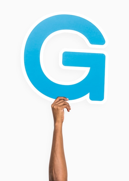 Hand holding the letter G