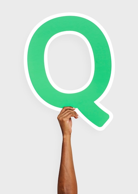 Hand holding the letter Q