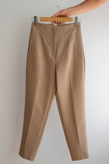 Free photo hand holding light brown beige pants