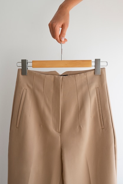 Free photo hand holding light brown beige pants