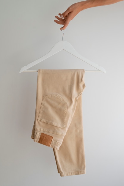 Hand holding light brown beige pants