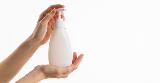 Hand holding liquid soap bottle with copy space