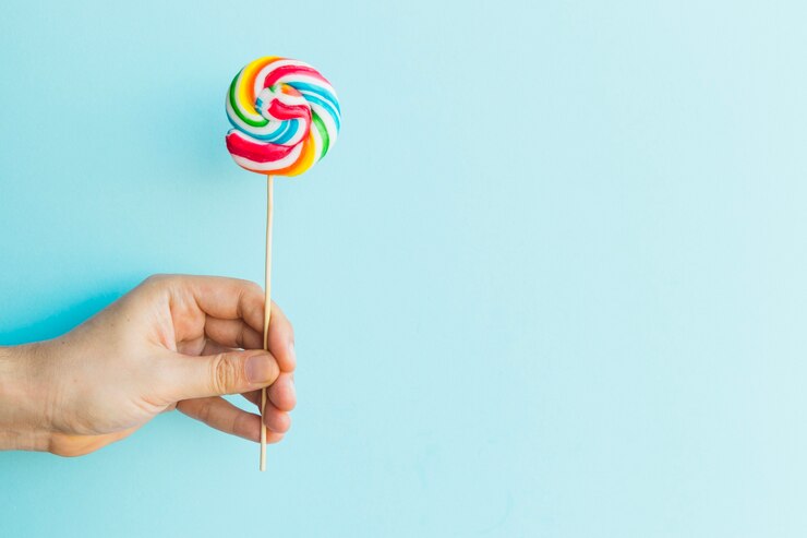 Free Photo hand holding lollipop