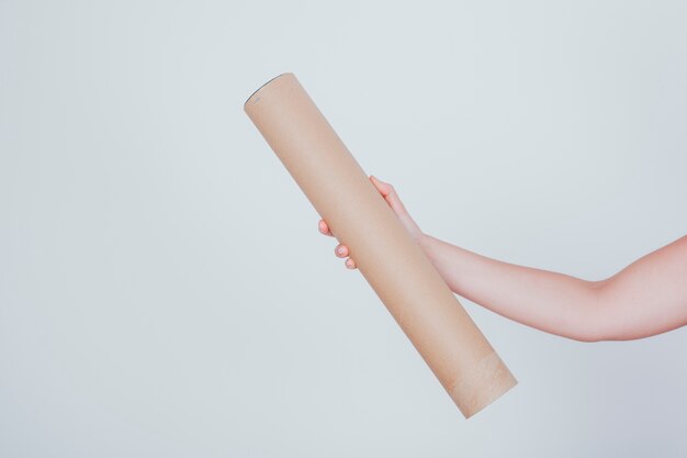 hand holding long cardboard tube