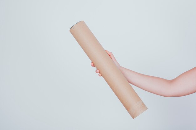 Hand holding long cardboard tube