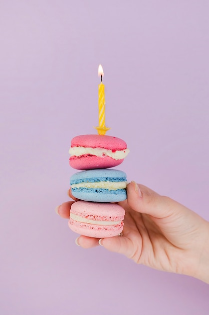 Hand holding macaroons for birthday concept