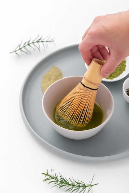 Free photo hand holding matcha bamboo whisk