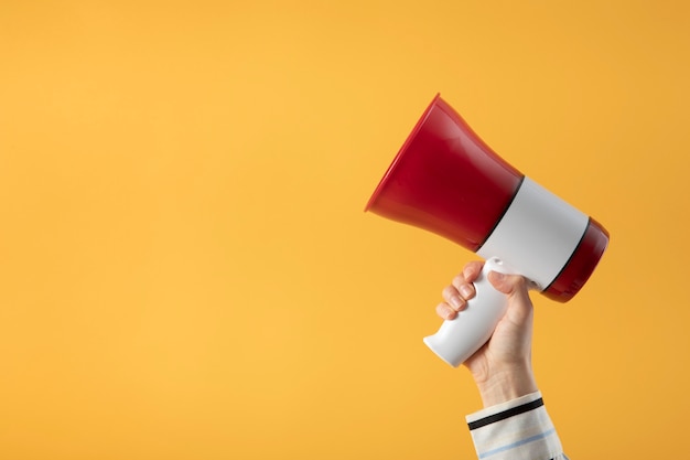 Free photo hand holding megaphone side view