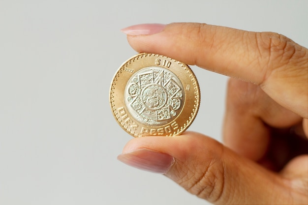 Free photo hand holding mexican coin close up