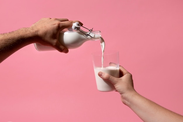 Рука, держащая бутылку с молоком, натюрморт