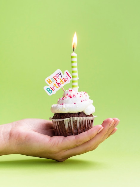 Hand holding muffin with happy birthday sign