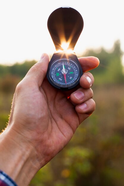 Hand holding open compass in the air