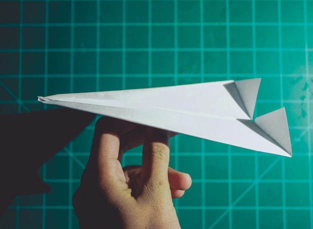 Free photo hand holding a paper airplane engineering background