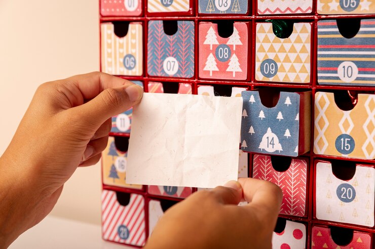 Free Photo hand holding paper sheet in front of advent calendar