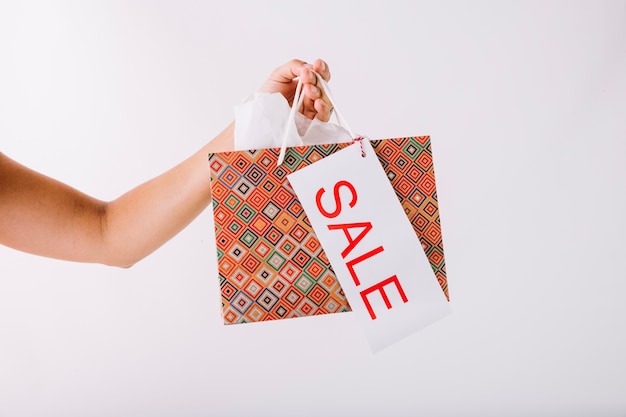 Free photo hand holding patterned paper bag