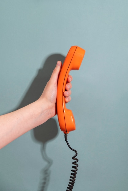 hand holding phone with blue background side view