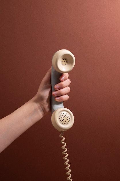 hand holding phone with brown background