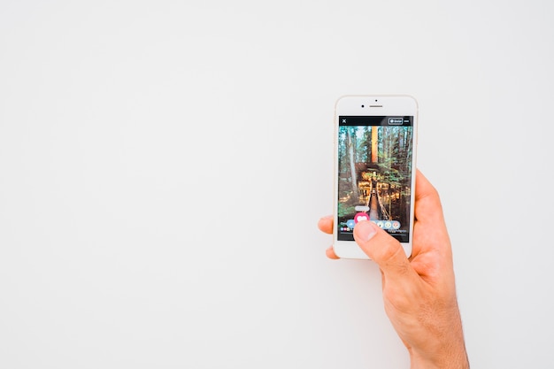 Hand holding phone with facebook photo and copy space